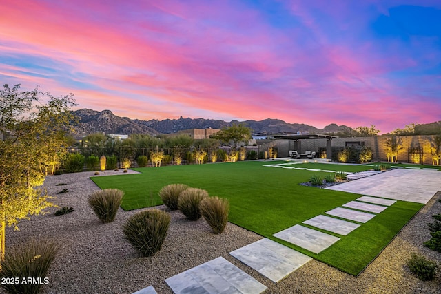 yard at dusk featuring a mountain view