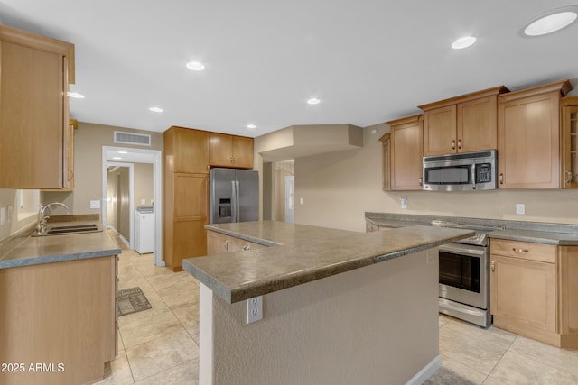 kitchen with light tile patterned flooring, appliances with stainless steel finishes, sink, and a kitchen island