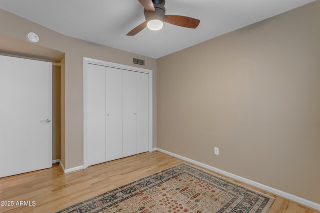 bedroom featuring hardwood / wood-style floors, a closet, and ceiling fan