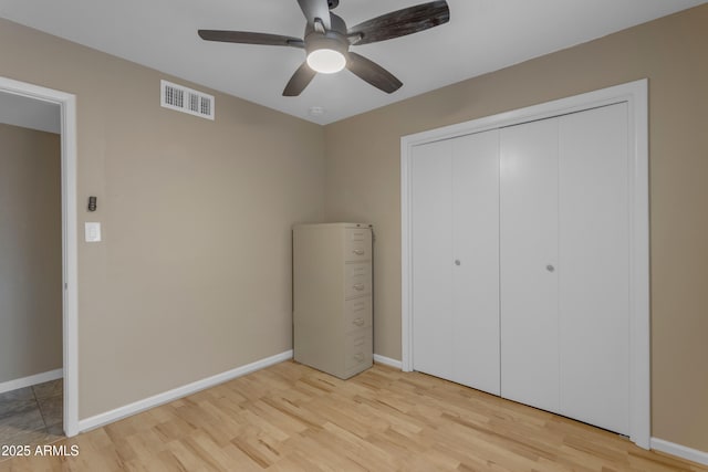 unfurnished bedroom featuring ceiling fan, a closet, and light hardwood / wood-style floors