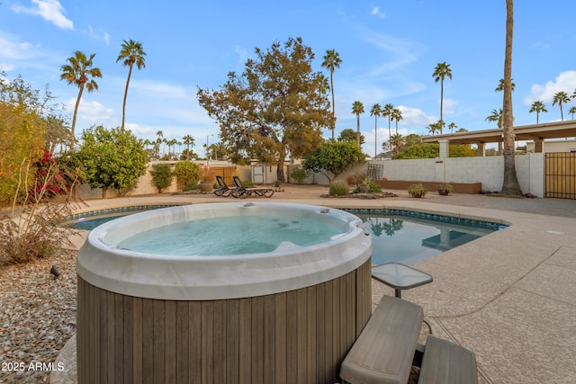 view of swimming pool with a patio and a hot tub