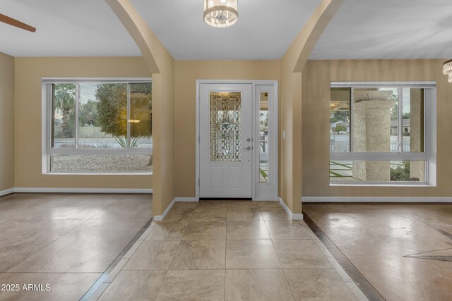 foyer with light tile patterned flooring and an inviting chandelier