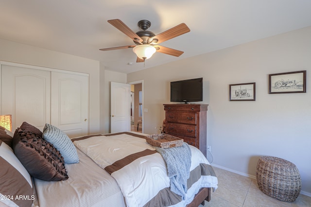 bedroom featuring ceiling fan, light tile patterned floors, and a closet