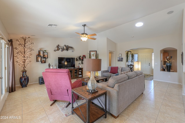 living room featuring ceiling fan, light tile patterned floors, and vaulted ceiling