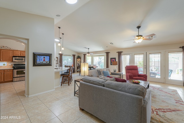 tiled living room featuring ceiling fan, french doors, a healthy amount of sunlight, and vaulted ceiling