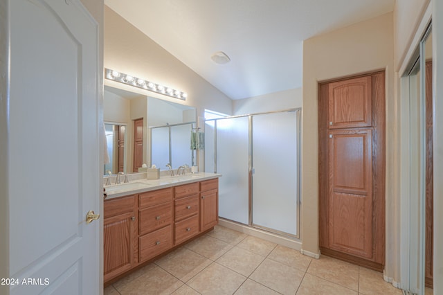 bathroom with tile patterned flooring, vanity, vaulted ceiling, and walk in shower