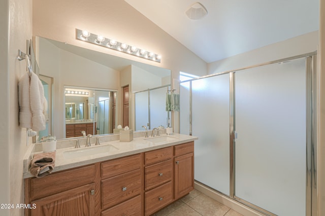 bathroom featuring tile patterned floors, vanity, a shower with shower door, and lofted ceiling