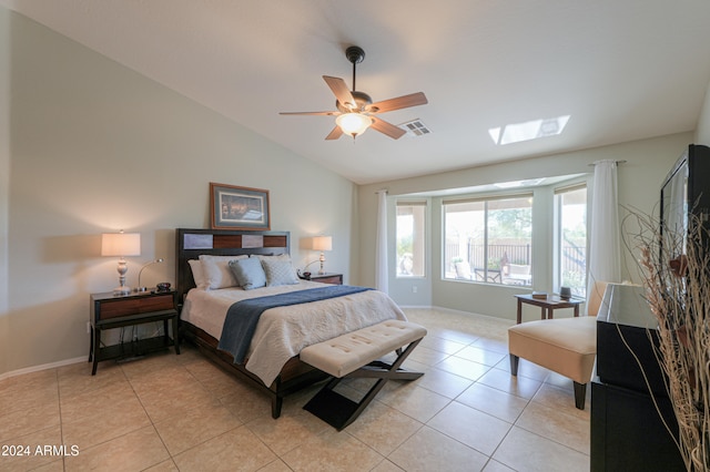 tiled bedroom featuring ceiling fan and lofted ceiling with skylight