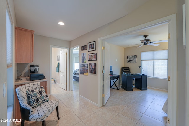 interior space with ceiling fan, light brown cabinetry, and light tile patterned floors