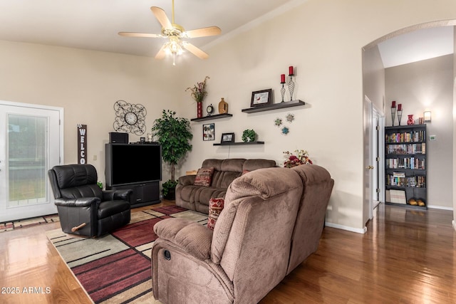 living room with ceiling fan and dark wood-type flooring