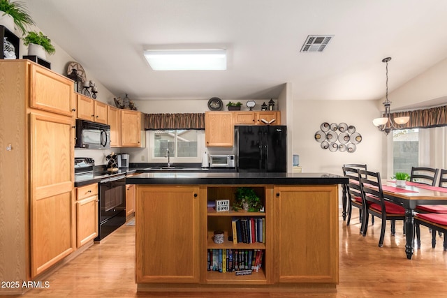 kitchen featuring pendant lighting, a kitchen island, black appliances, and light hardwood / wood-style flooring