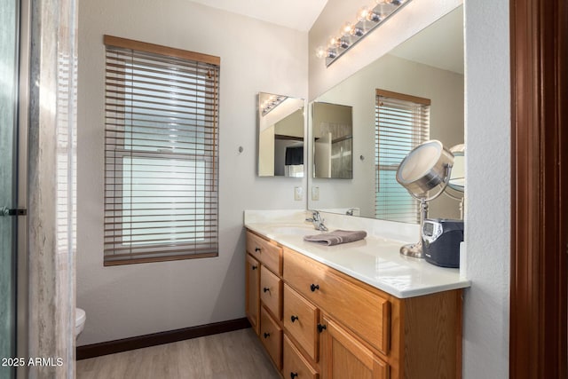 bathroom with toilet, vanity, and hardwood / wood-style flooring