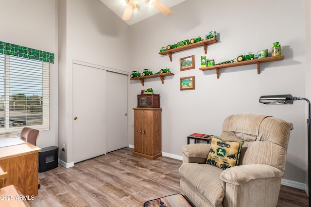 living area featuring vaulted ceiling, light hardwood / wood-style flooring, and ceiling fan