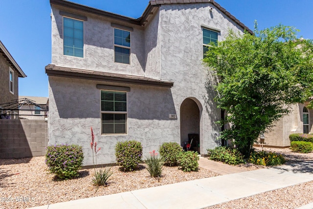 view of front of home with stucco siding and fence
