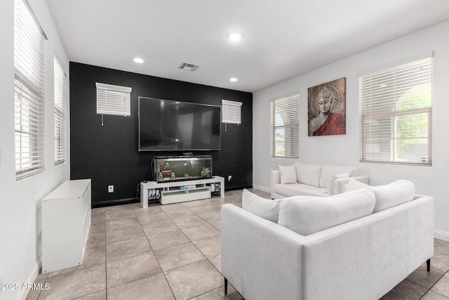 living room with baseboards, recessed lighting, an accent wall, and light tile patterned floors
