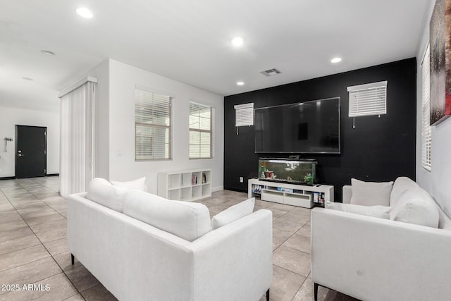 living room with recessed lighting, light tile patterned floors, and an accent wall
