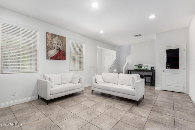 living area with light tile patterned floors, recessed lighting, baseboards, and stairs