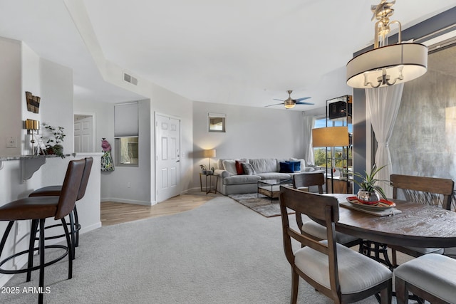 dining space featuring ceiling fan and light colored carpet