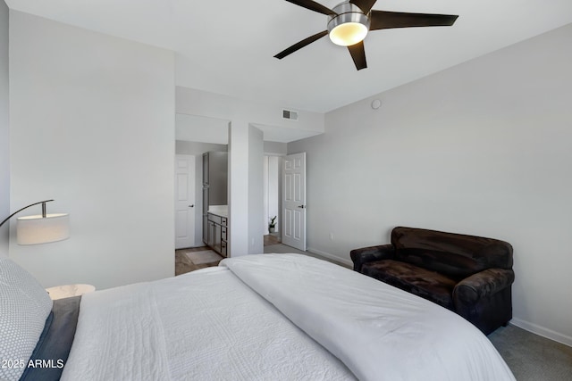 bedroom with ceiling fan, ensuite bathroom, and light carpet