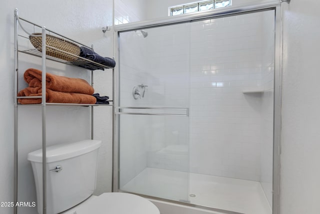 bathroom with walk in shower and toilet