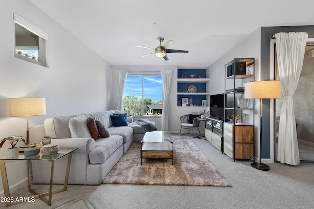 carpeted living room featuring ceiling fan and built in features