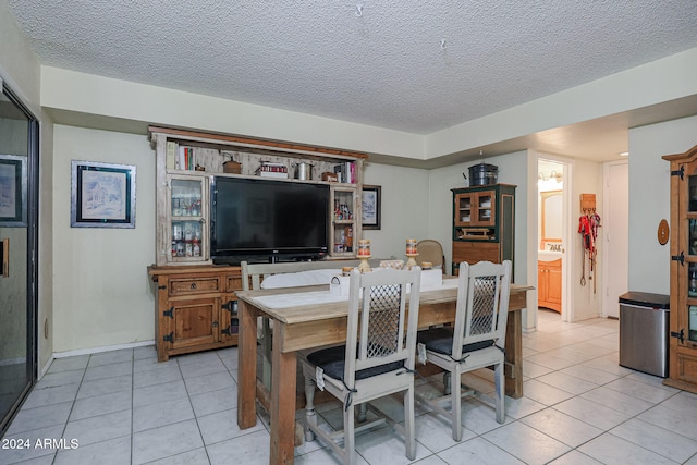 tiled dining space with a textured ceiling