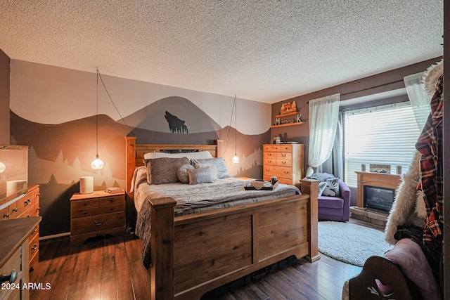 bedroom with a textured ceiling and dark hardwood / wood-style floors