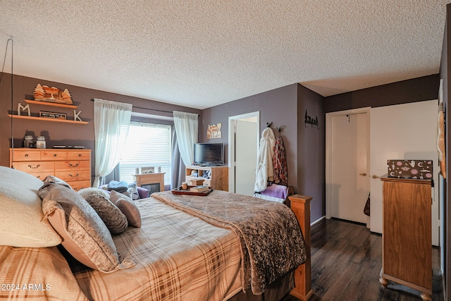 bedroom featuring a textured ceiling and dark wood-type flooring