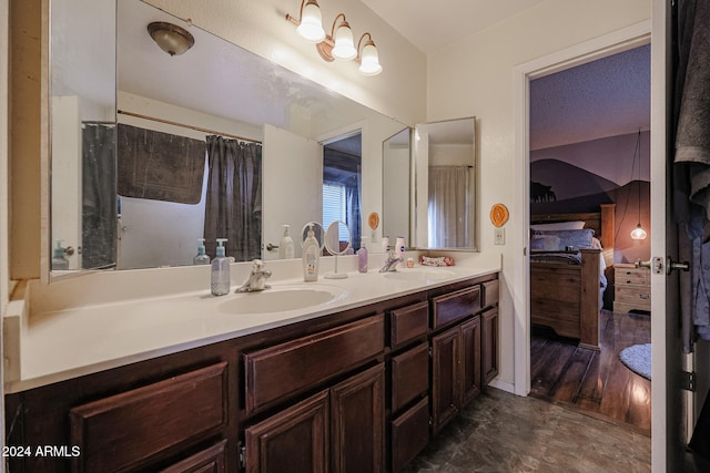 bathroom with hardwood / wood-style floors, vanity, and a textured ceiling