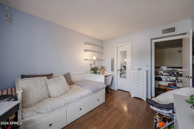 living room with a textured ceiling and dark wood-type flooring