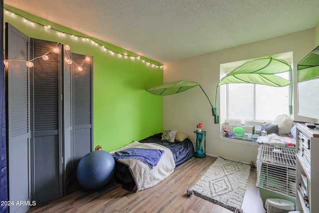 bedroom featuring wood-type flooring and a textured ceiling