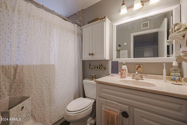 bathroom featuring vanity, toilet, and curtained shower