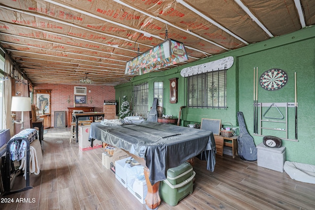 game room with hardwood / wood-style flooring, brick wall, and pool table