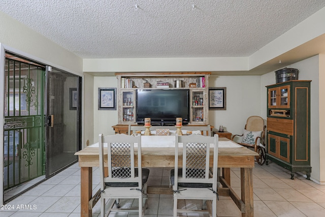 dining room featuring light tile patterned floors and a textured ceiling