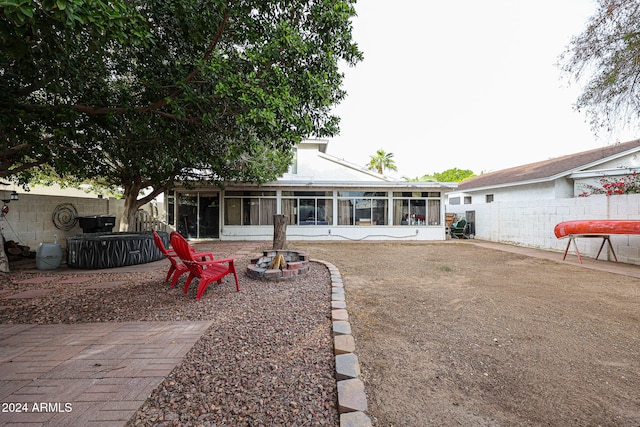 back of house with a patio, an outdoor fire pit, and a sunroom