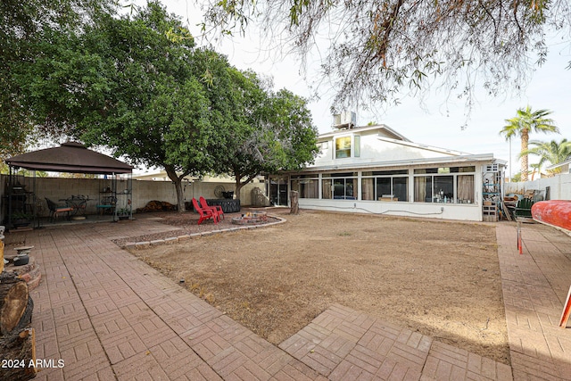 back of property featuring a gazebo, a patio area, and a sunroom