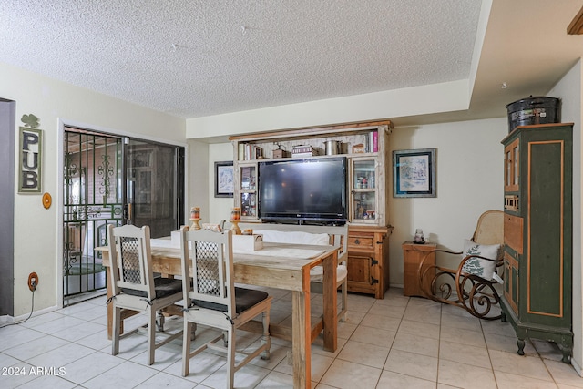 dining space featuring light tile patterned floors and a textured ceiling