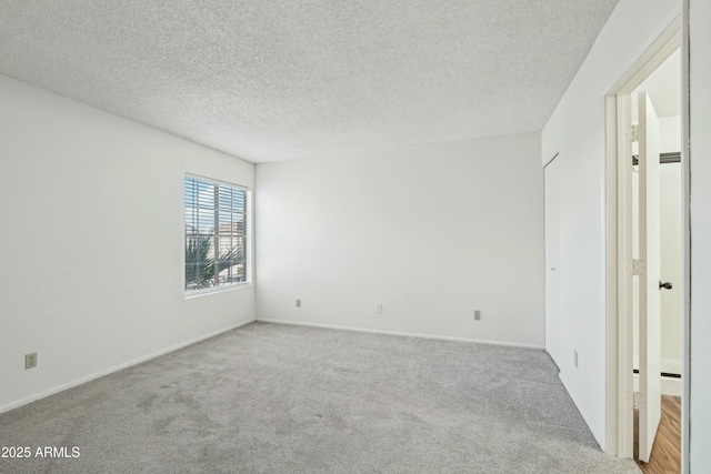 empty room featuring light carpet and a textured ceiling