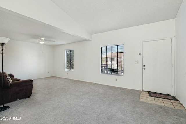 living room featuring vaulted ceiling, light carpet, and ceiling fan