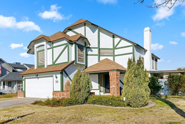 tudor home featuring a garage and a front lawn