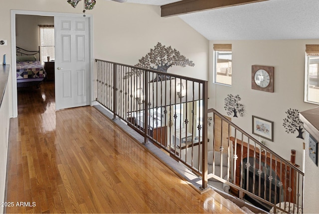 corridor with vaulted ceiling with beams and hardwood / wood-style floors