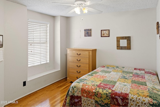 bedroom featuring hardwood / wood-style floors, a textured ceiling, and ceiling fan