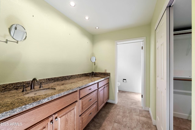 bathroom featuring vanity, tile patterned flooring, and toilet