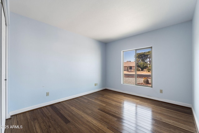 spare room featuring dark wood-type flooring