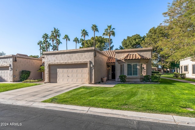 mediterranean / spanish-style house featuring a front yard and a garage