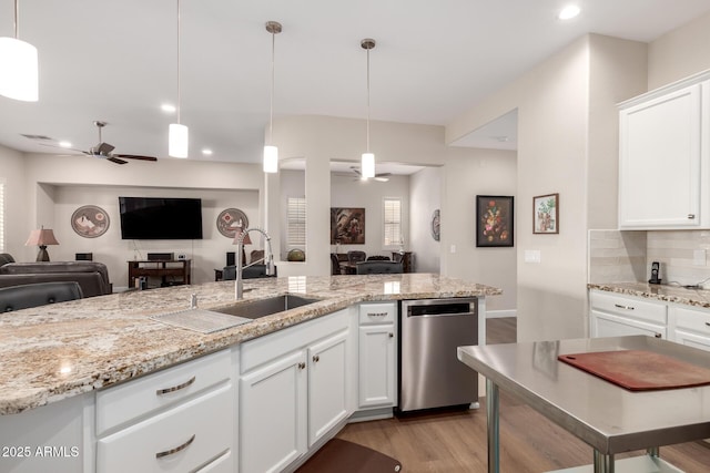 kitchen featuring light wood-type flooring, a sink, stainless steel dishwasher, open floor plan, and ceiling fan