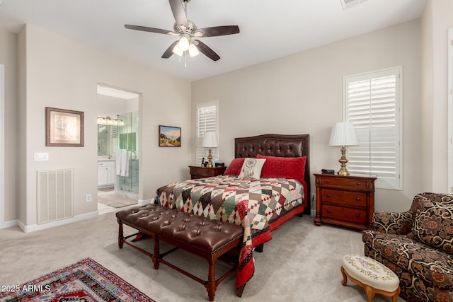 bedroom featuring visible vents, connected bathroom, carpet floors, baseboards, and ceiling fan