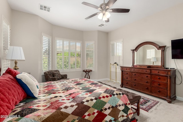 bedroom featuring a ceiling fan, baseboards, visible vents, and light carpet