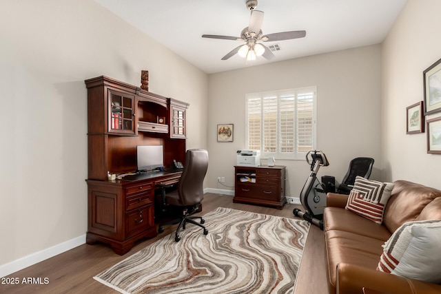 office area with a ceiling fan, baseboards, and wood finished floors