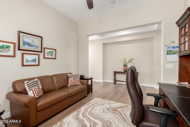 office area featuring baseboards, light wood-type flooring, and ceiling fan